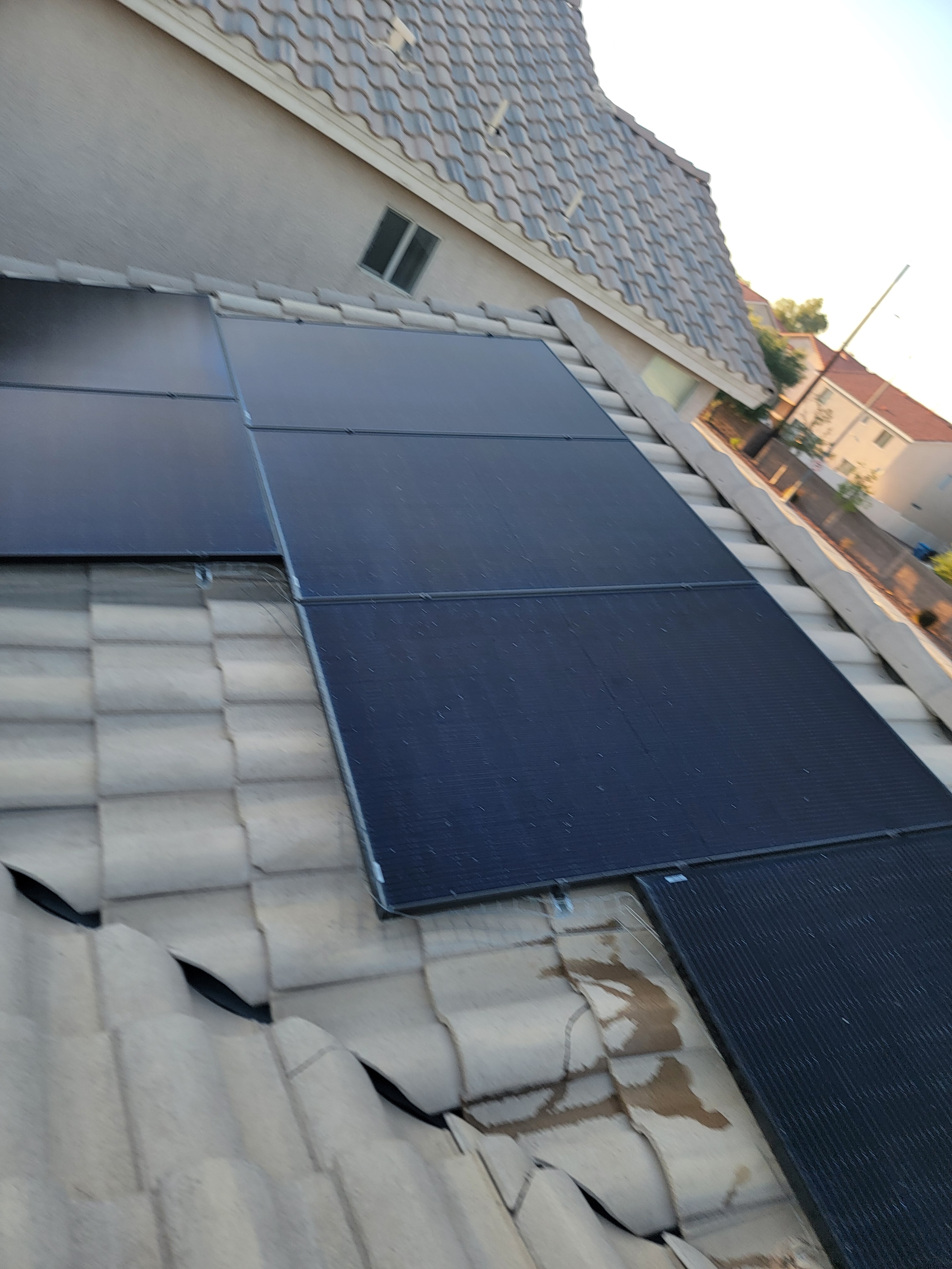 Dirty solar panels on tile roof close-up before professional cleaning